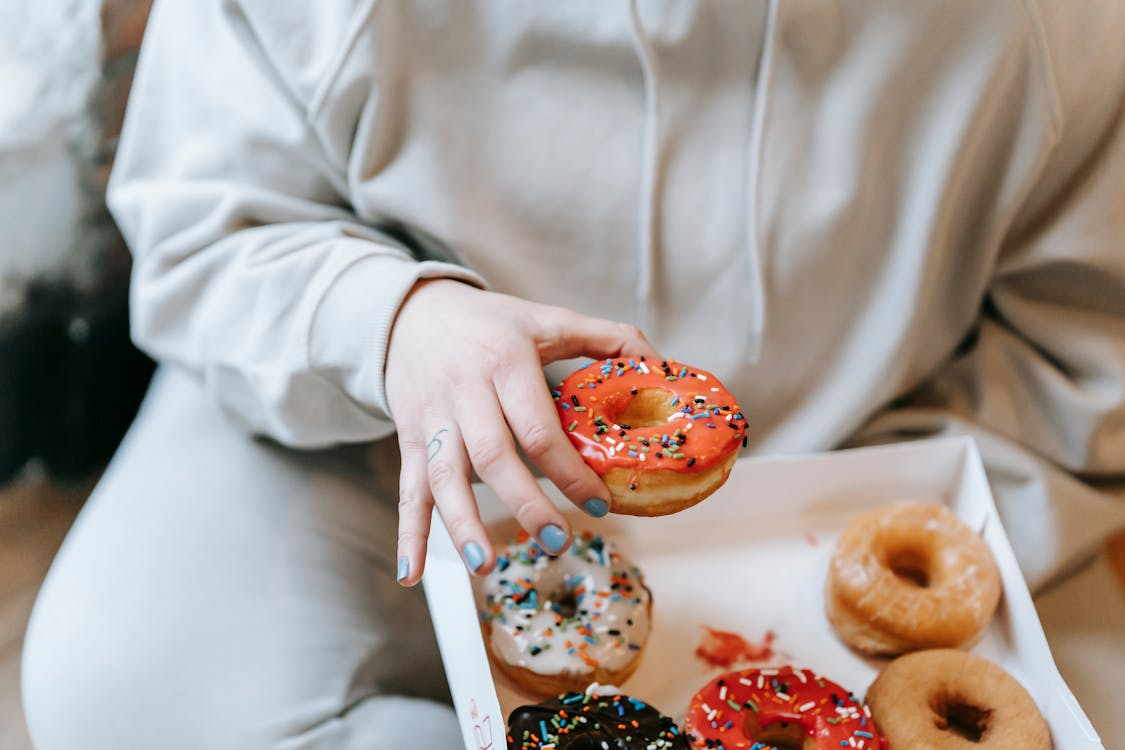 person choosing donuts illustrating what happens when you cut out sugar