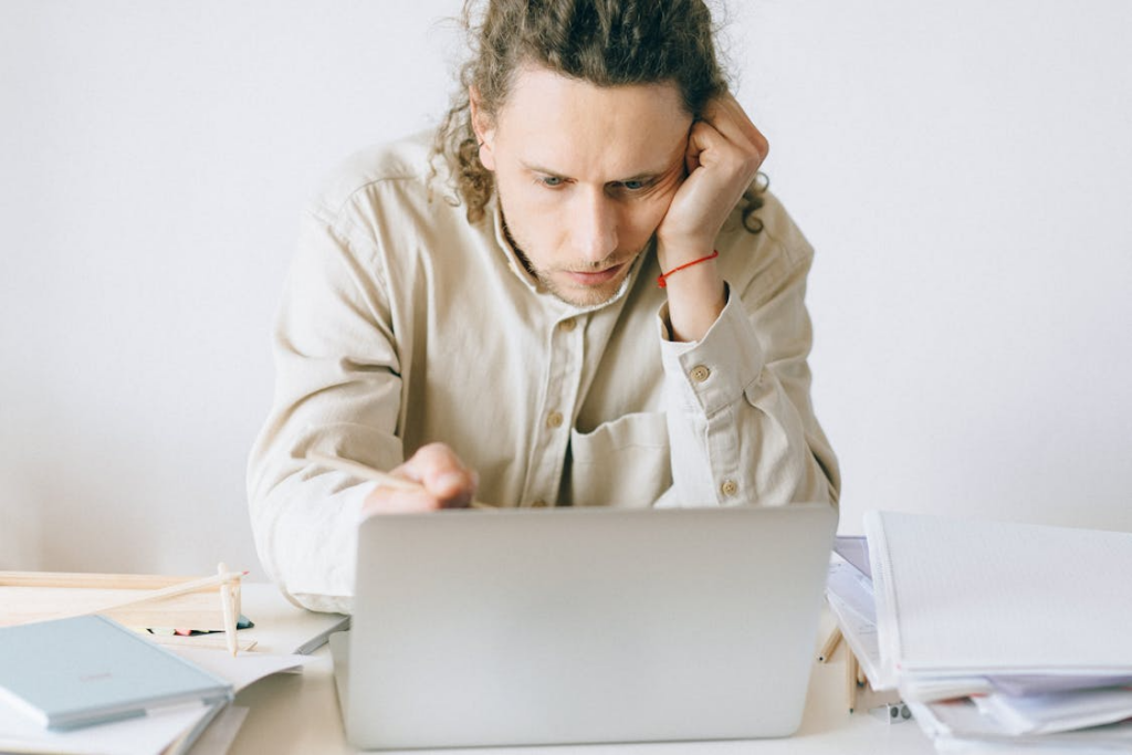 person struggling to focus on laptop illustrating what is brain fog