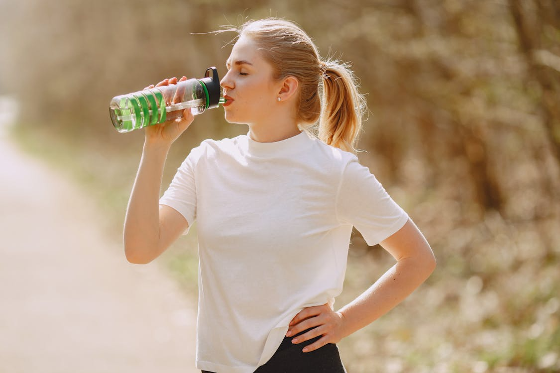 person drinking water outdoors illustrating how dehydration affects the body